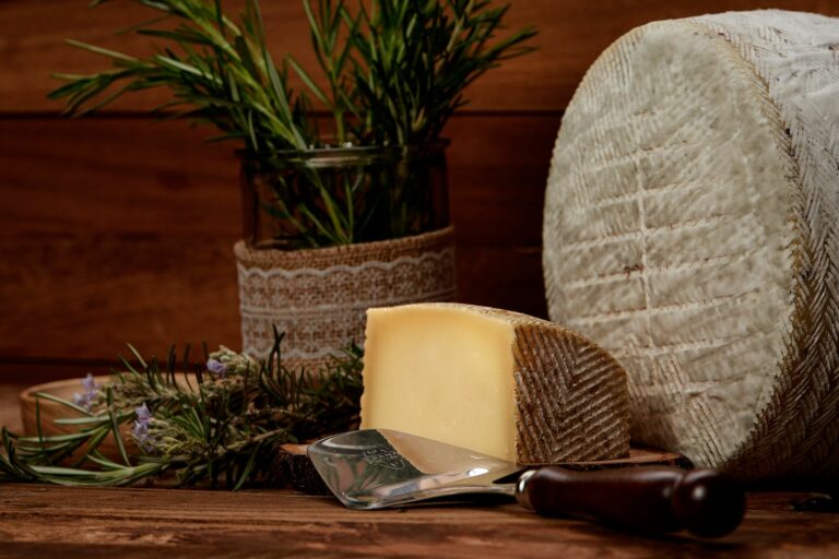 Queso de oveja curado de corteza natural junto a una cuña
